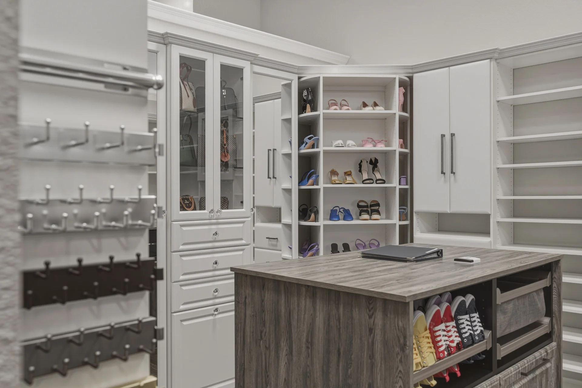 Dream Closets LLC showroom walk-in closet with glass-front cabinets and rotating shoe display in Bradenton FL